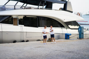 business partnership. two friends and a business partner near a private yacht in the port.